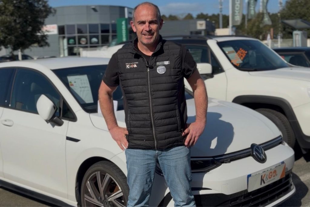 Stéphane souriant, devant une Volkswagen